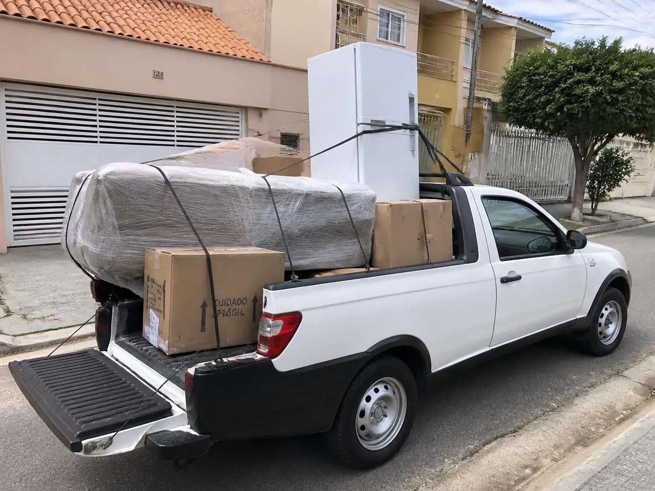 Caminhonete realizando pequeno frete em Juiz de Fora com sofá, geladeira e caixas organizadas